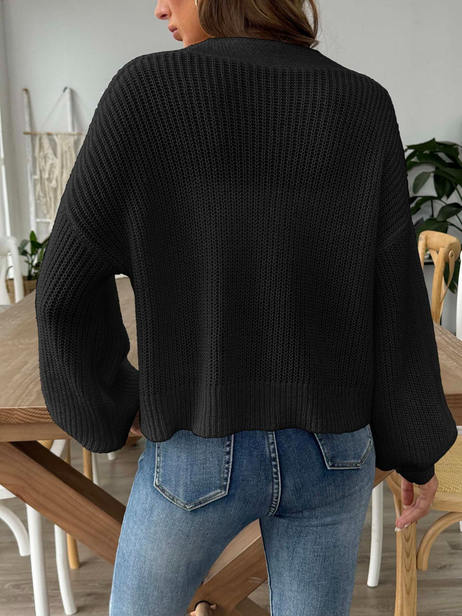 Black balloon sleeve cardigan with textured knit and button front detail.