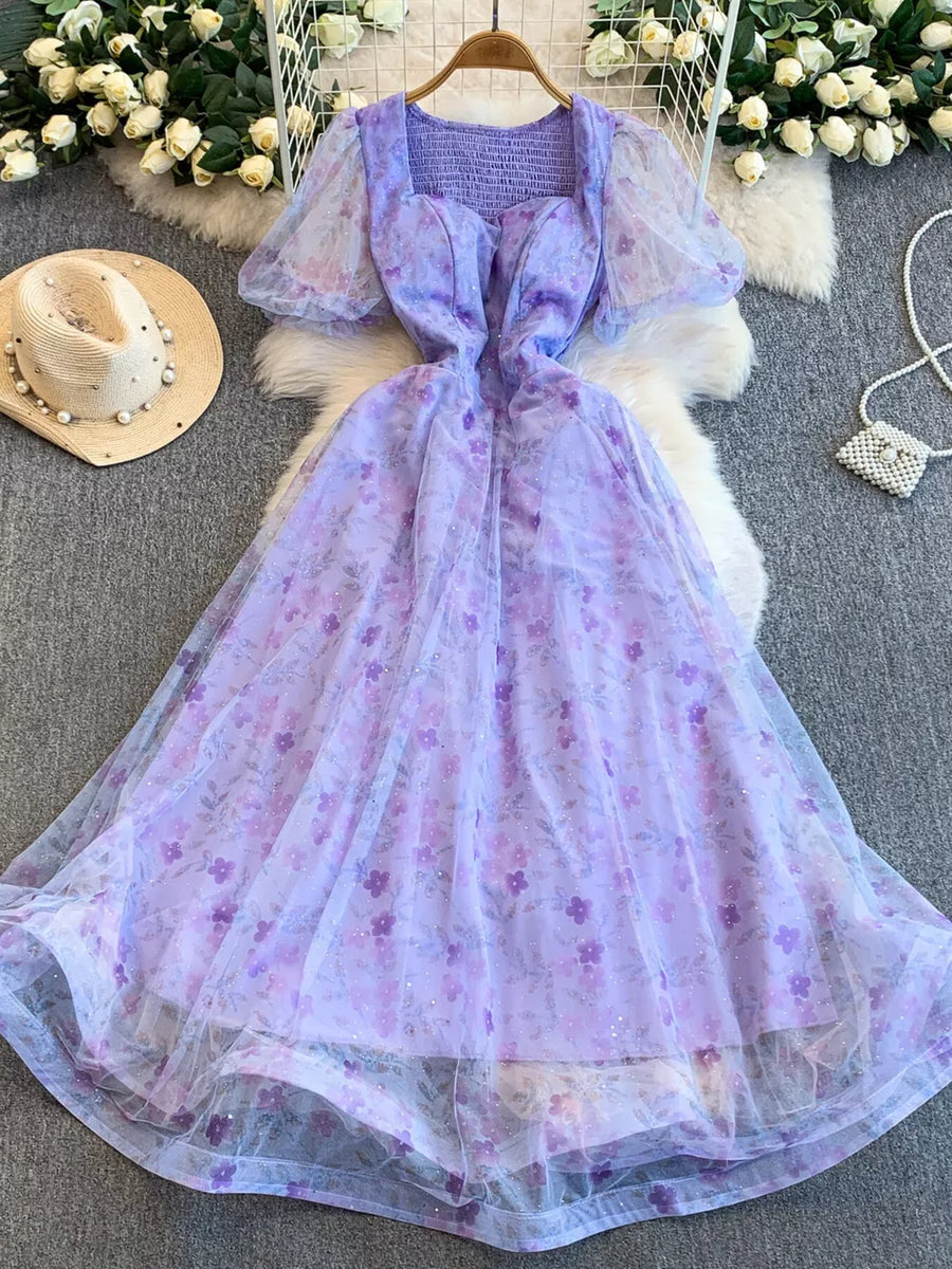 Purple floral maxi dress with sweetheart neckline, puff sleeves, and glitter tulle overlay.
