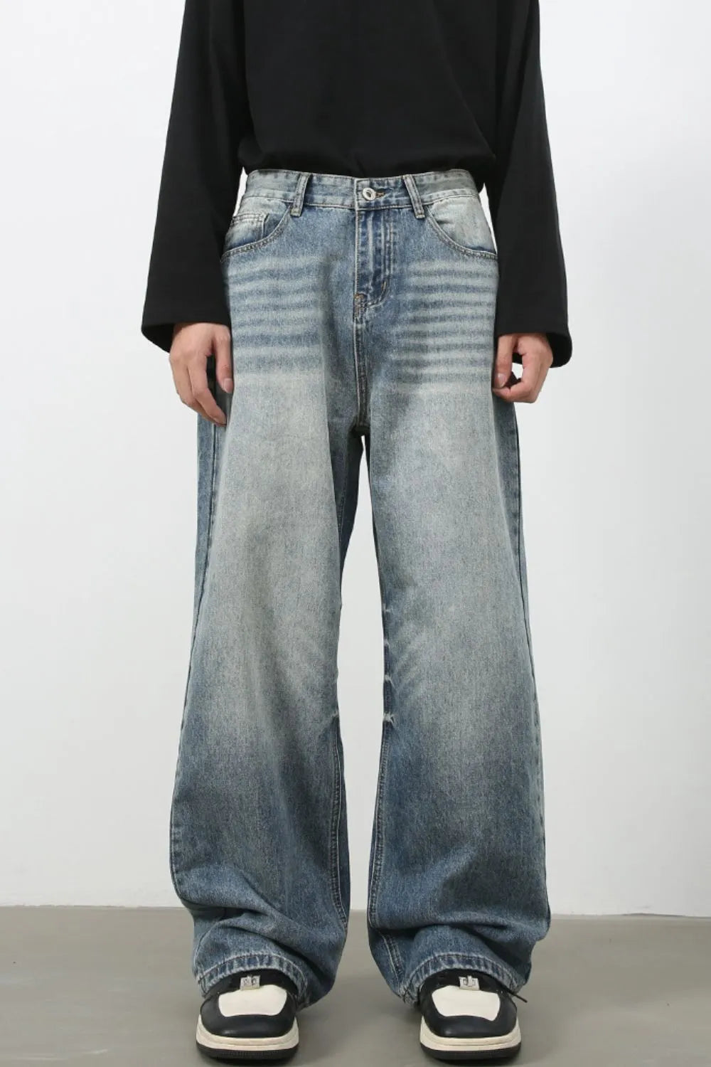 Baggy wash denim jeans in medium blue with a relaxed fit and distressed details.
