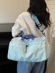 Chic two-tone aqua nylon travel bag with detachable strap and patterned front pocket.