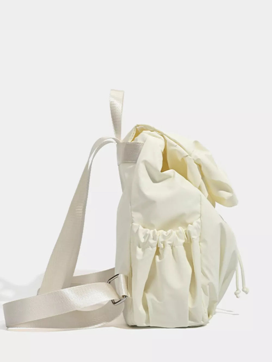 Cream nylon drawstring backpack with flap closure and adjustable straps.