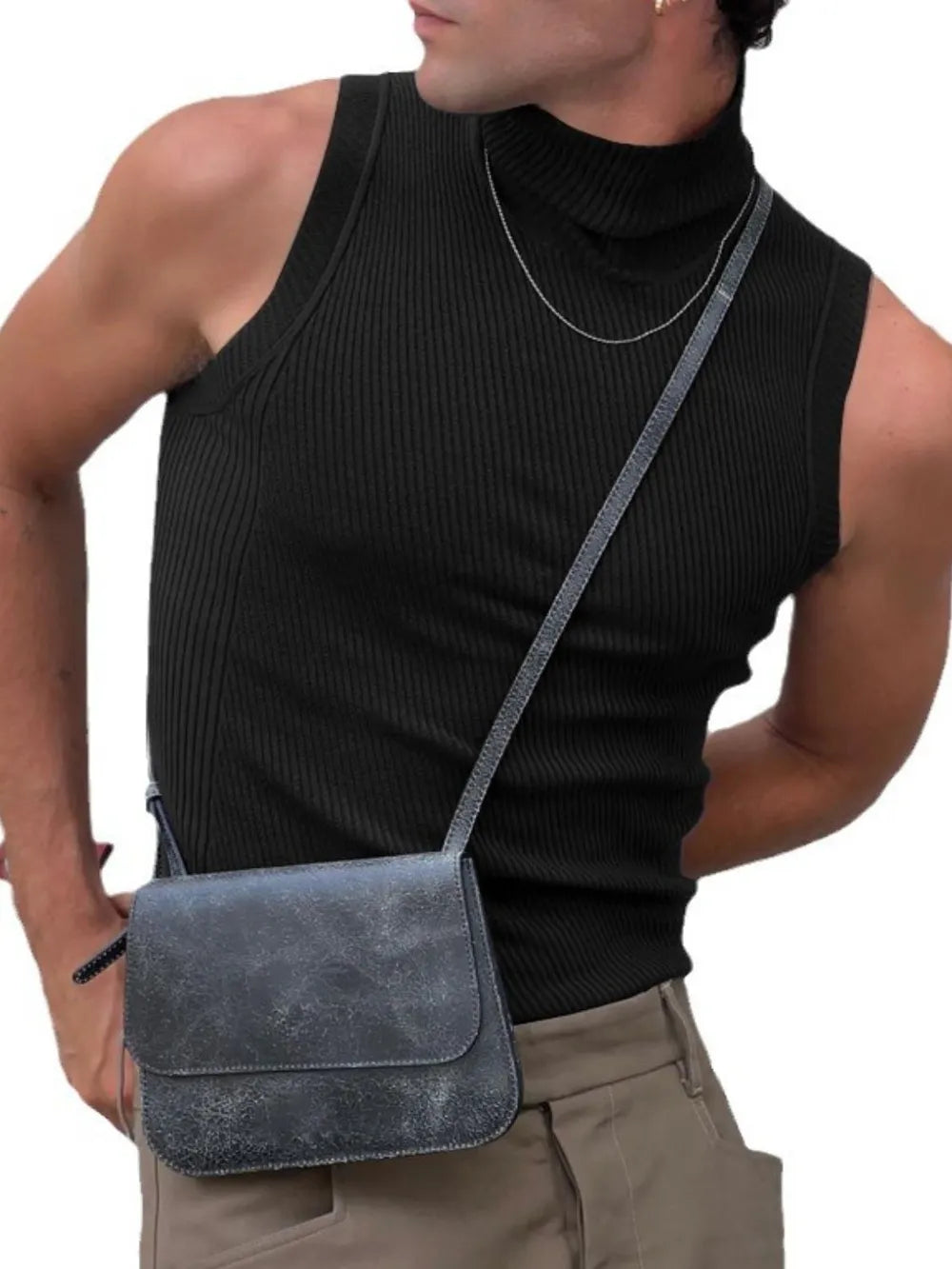 Black ribbed sleeveless turtleneck shirt with a high neck, styled with a crossbody bag.
