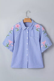 Blue and white striped button-down shirt with pink floral embroidery on the sleeves and shoulders.