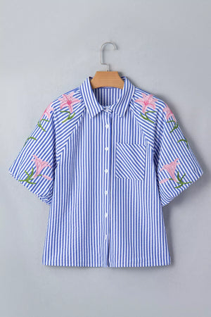 Blue and white striped button-down shirt with pink floral embroidery on the sleeves and shoulders.