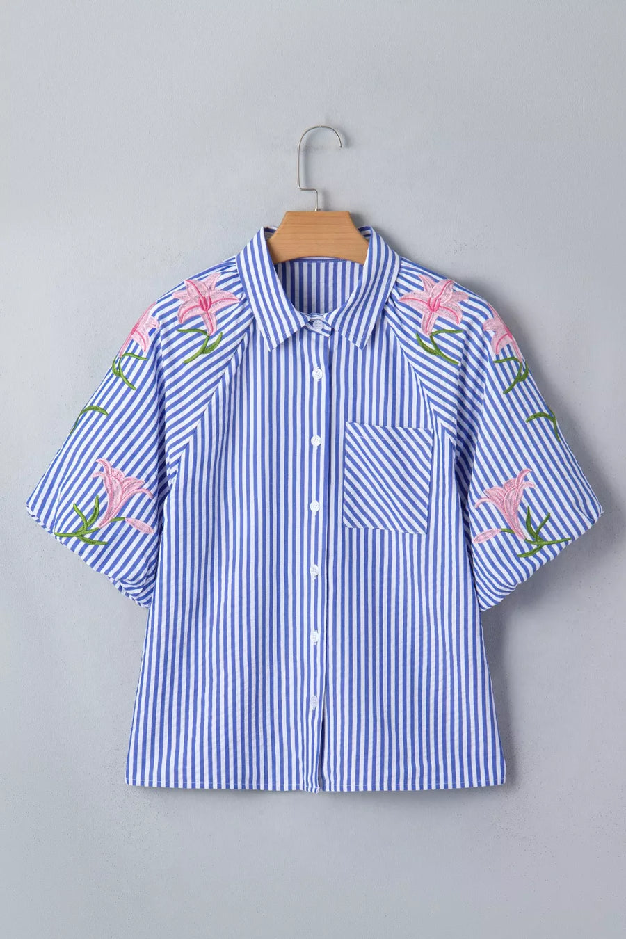 Blue and white striped button-down shirt with pink floral embroidery on the sleeves and shoulders.