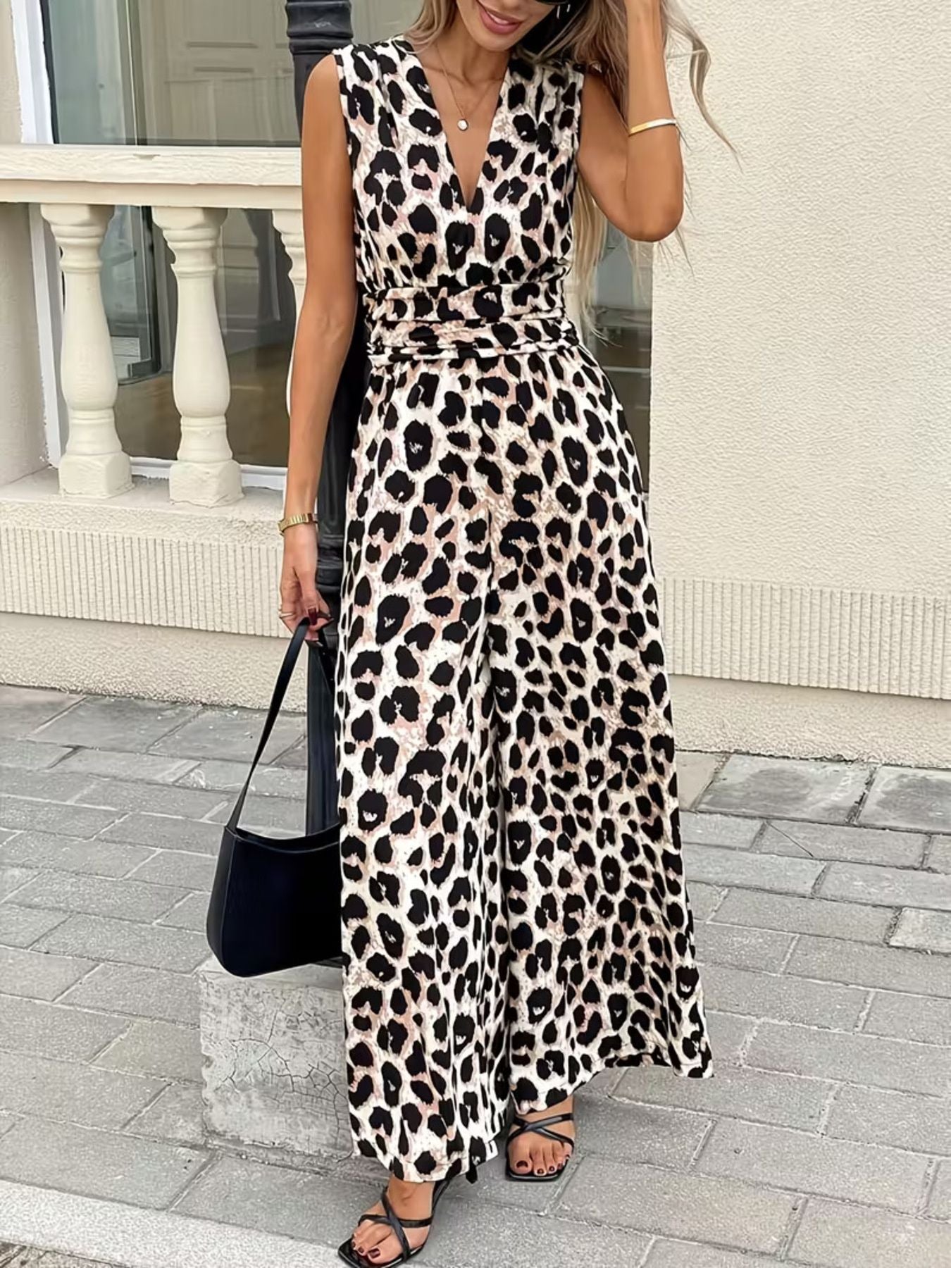 Chic sleeveless leopard print romper with V-neck and belted waist, wide leg pants.