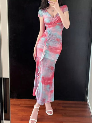 Surplice ruffle maxi dress in pink and blue tie-dye with ruched side detail and a flowing hem.