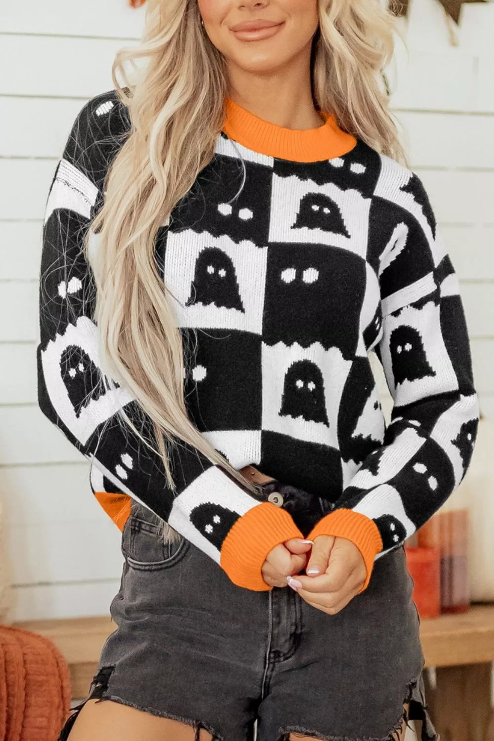 white pullover sweater featuring ribbed cuffs and checkerboard