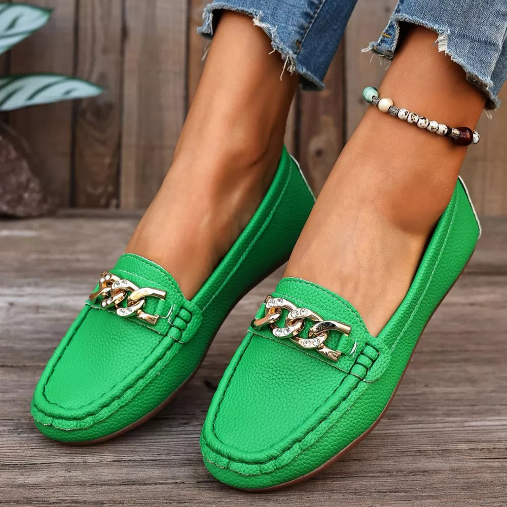 Green round-toe loafers with gold chain detail and rhinestone accents.