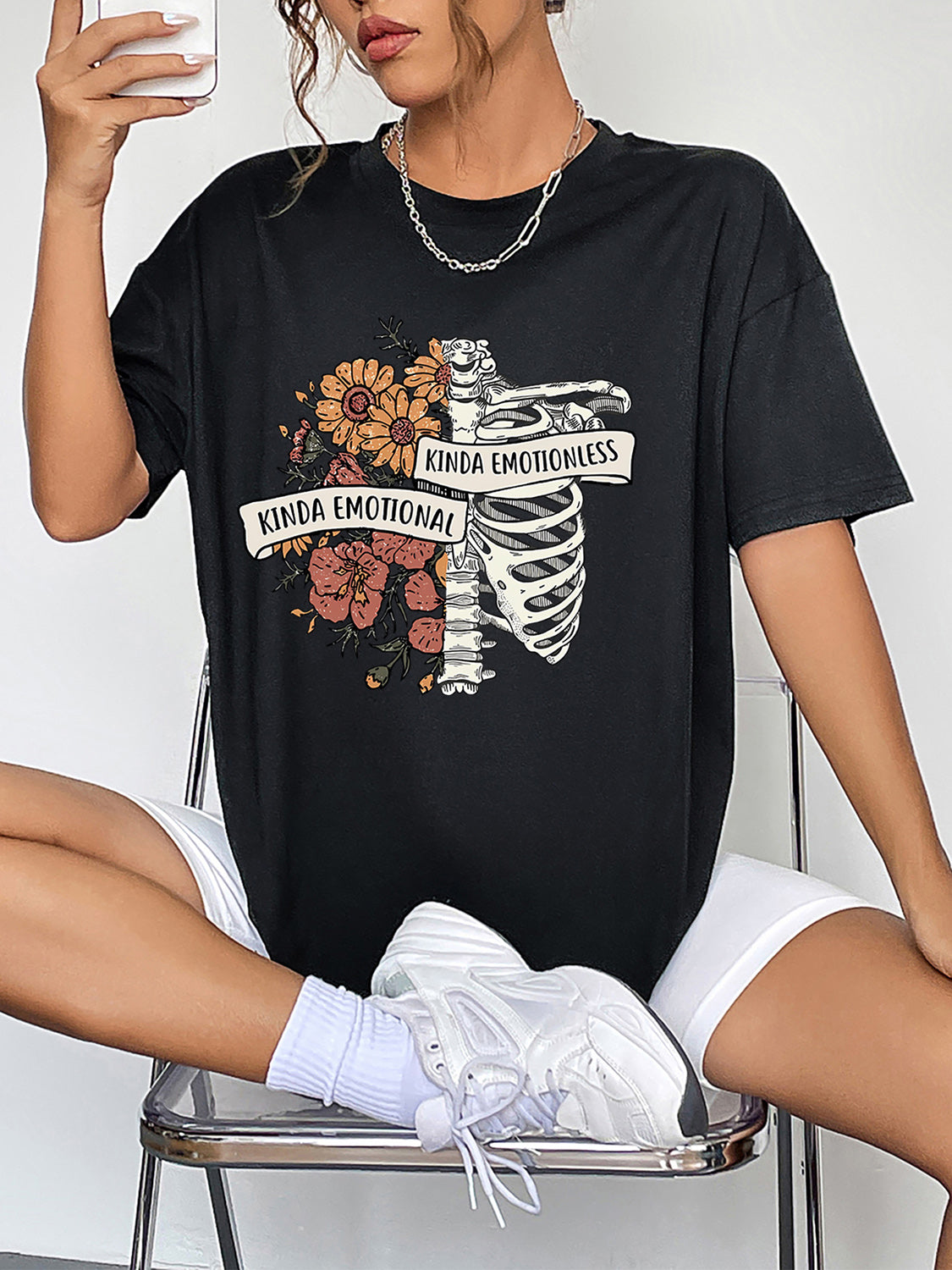 Black polyester t-shirt with a skeleton and floral graphic that says Kinda Emotional.
