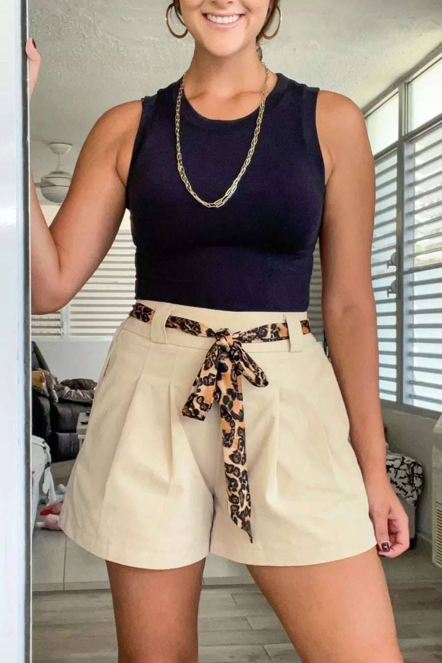 Cream pleated shorts with leopard print tie belt and navy sleeveless top