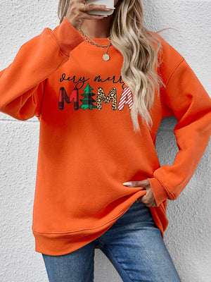 Orange long sleeve sweater with abstract "Very Merry Mama" graphic print.