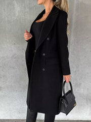Black double-breasted longline trench coat with button detail and lapel collar.