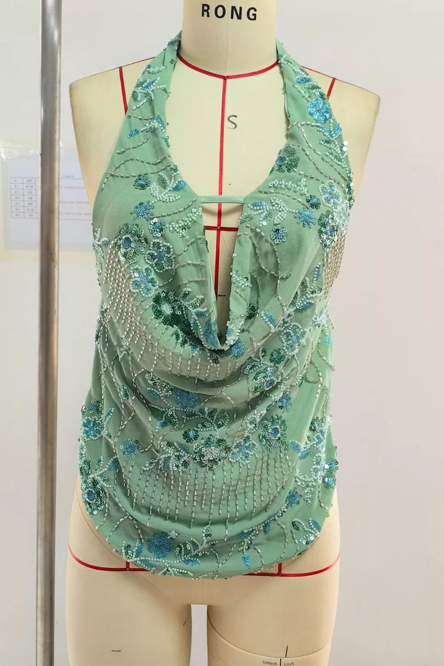 Mint green halter top with floral bead and sequin embellishments and a cowl neck.