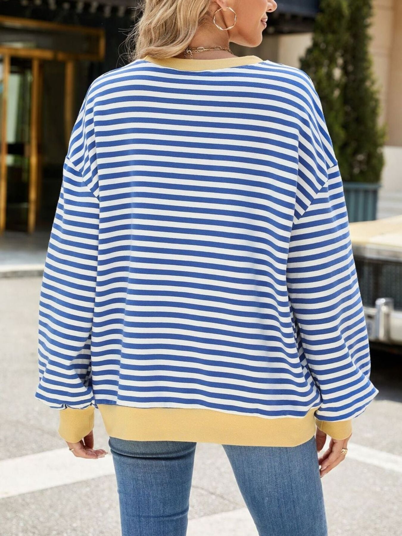 Striped crew neck sweatshirt in royal blue and white with a yellow hem and cuffs.