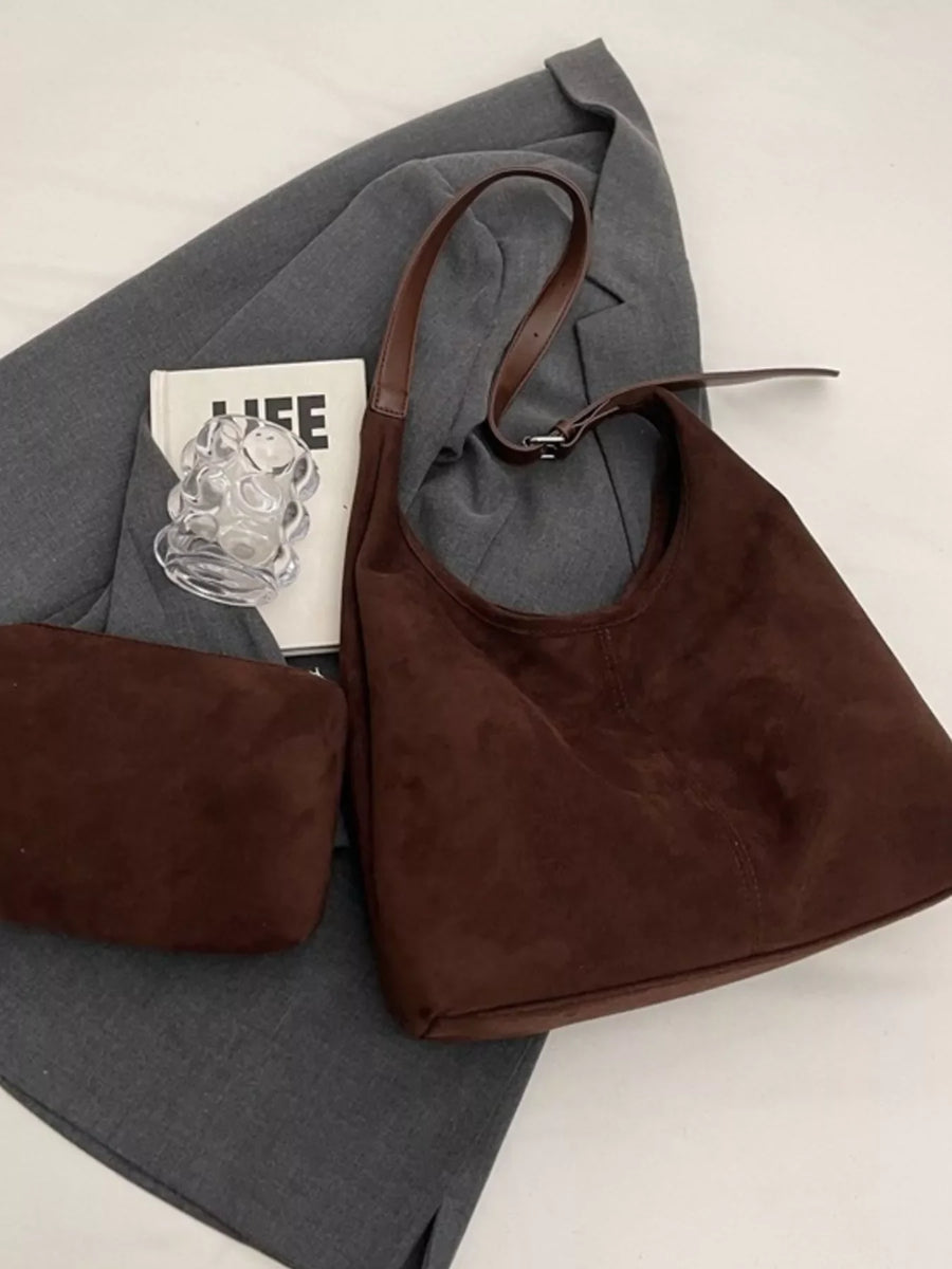 Brown suede hobo bag with adjustable strap and matching pouch.