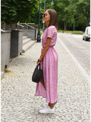 Maxi dress in lilac with an orange abstract print, short sleeves, V-neck, and a cinched waist.