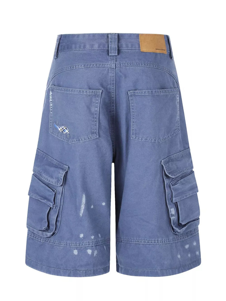 Blue faded cargo capris with distressed paint splatters and stylish patch detail.