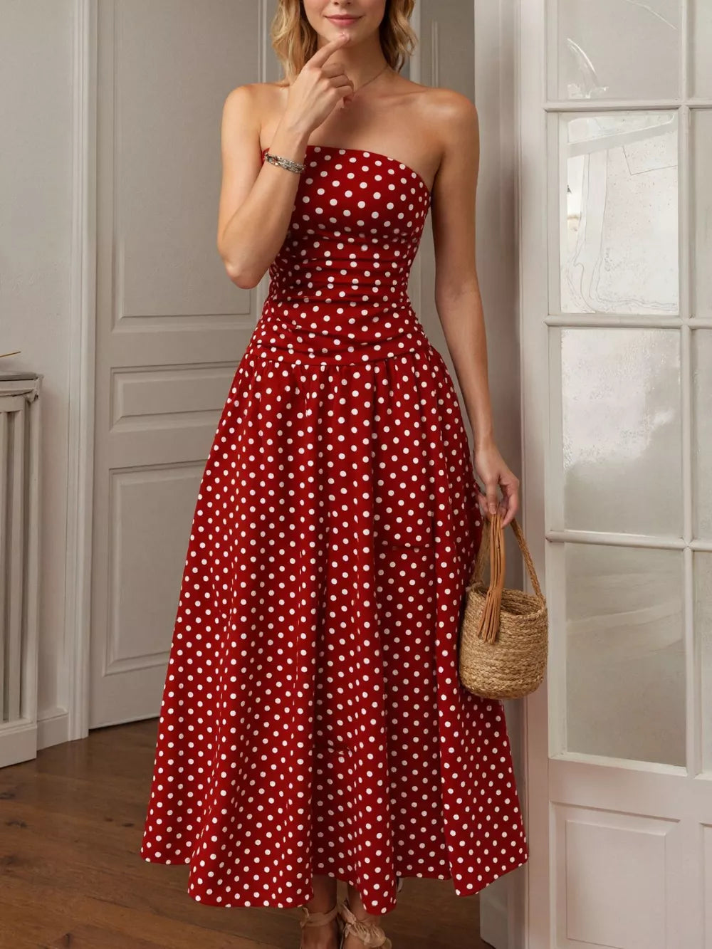 Red polka dot strapless maxi dress with a cinched waist and full skirt.