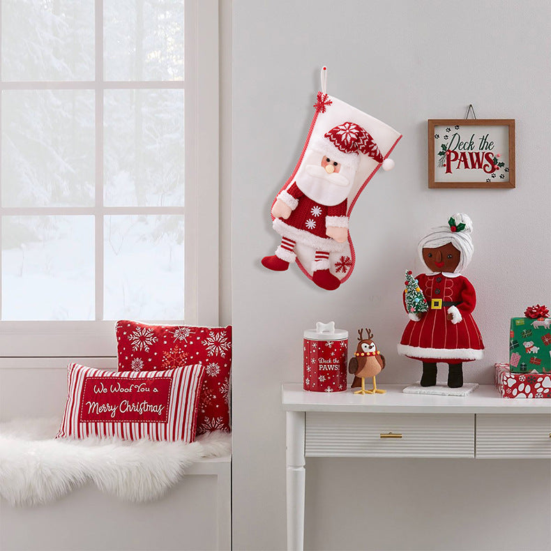 Plush Santa Christmas stocking with red and white details, hanging on wall.