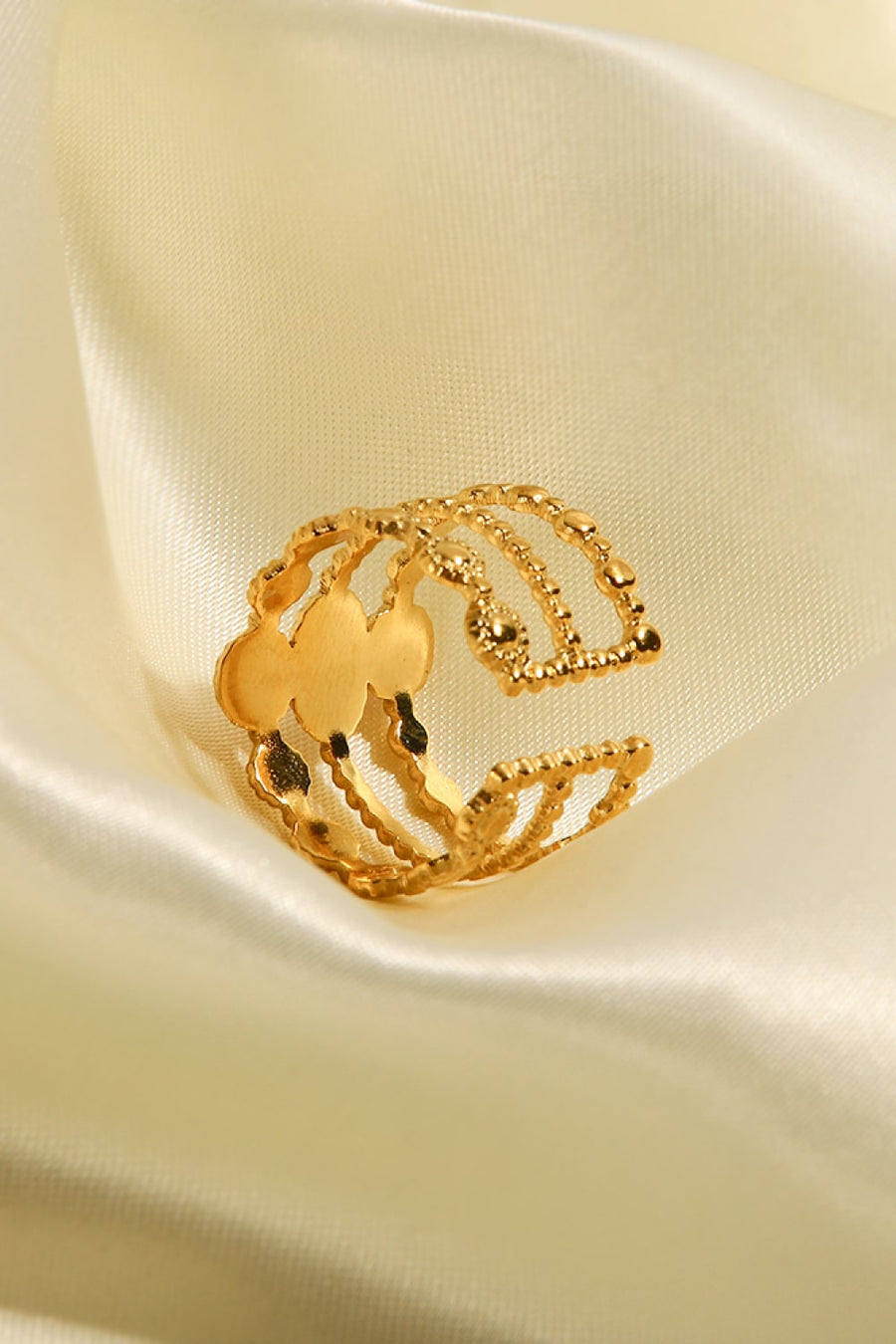 Gold triple stone openwork ring with beaded detail and cutouts.