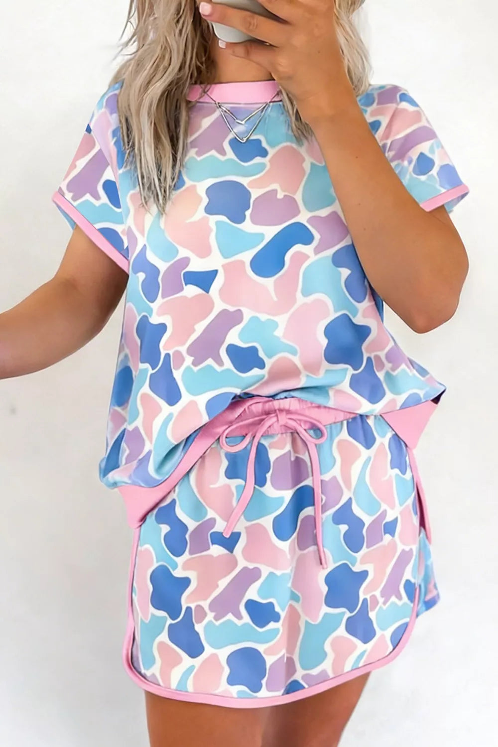 Pastel camouflage athletic two-piece set with crew neck top and drawstring shorts.