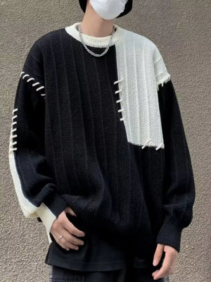Oversized black and white color block sweater with contrast stitching and ribbed texture.