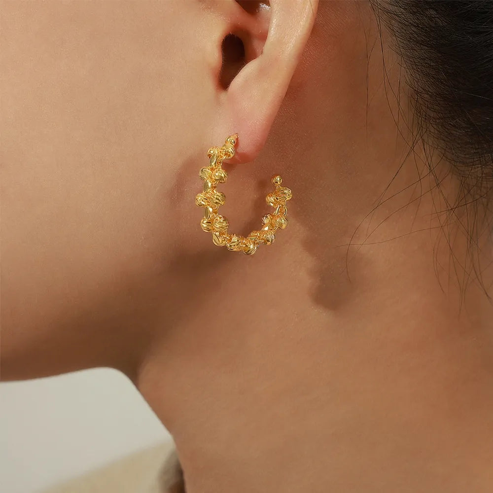 Gold textured orb C-hoop earrings with a unique beaded design.