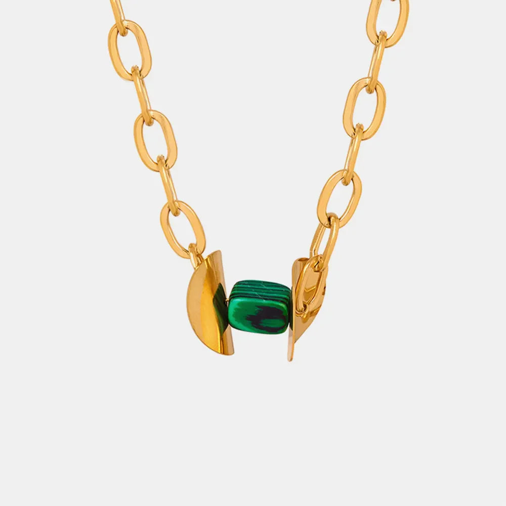 Geometric malachite pendant necklace with 18K gold-plated chain and abstract gold accents.