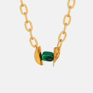 Geometric malachite pendant necklace with 18K gold-plated chain and abstract gold accents.