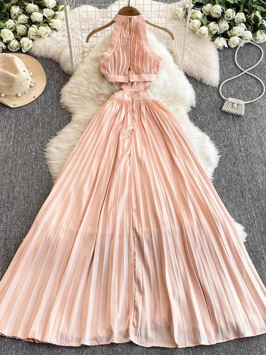 Pink pleated maxi dress with cutout details and halter neckline.