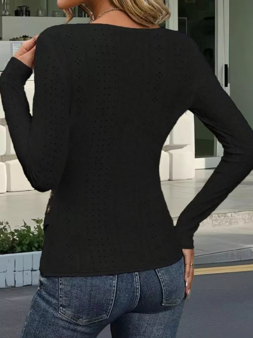 Black eyelet wrap t-shirt with decorative buttons and long sleeves.