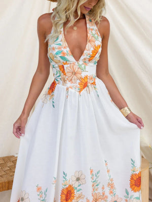 White floral halter neck maxi dress with plunging neckline and flowing skirt.