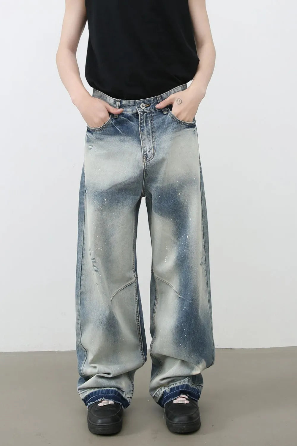 Distressed painterly wide-leg jeans in medium wash denim with paint splatters and a relaxed fit.