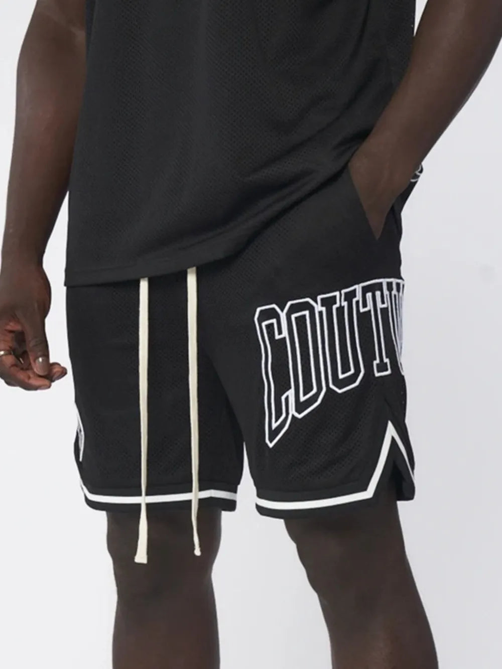 Black mesh athletic shorts with white "Couture" graphic and drawstring.