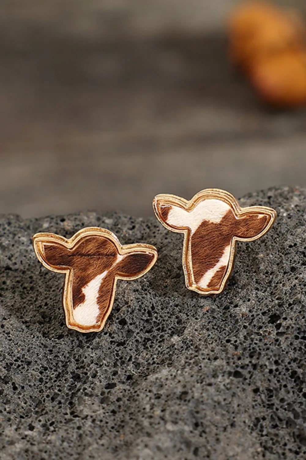 Cowhide silhouette stud earrings in copper with brown and white pattern.