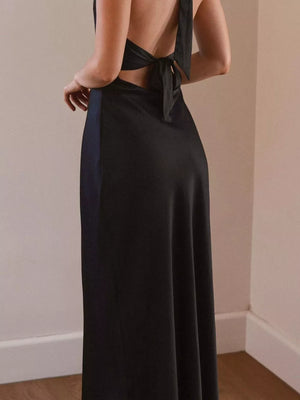Black backless halter neck maxi dress with tie detail and flowing skirt.