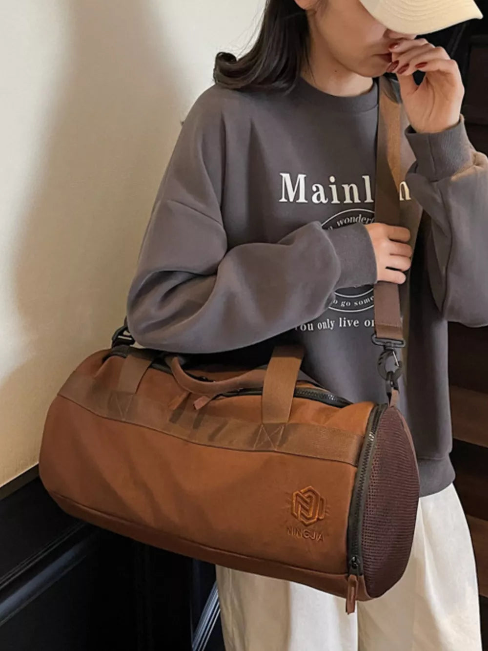 Brown Oxford cloth duffel bag with carry handles and adjustable strap