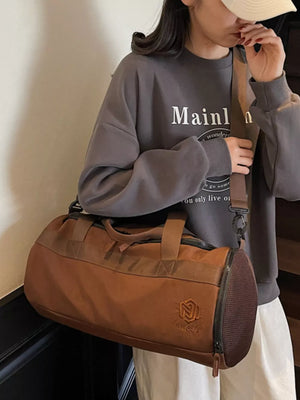 Brown Oxford cloth duffel bag with carry handles and adjustable strap