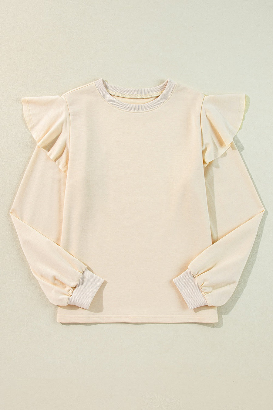 Cream ruffled shoulder sweatshirt with ribbed cuffs and crew neck.