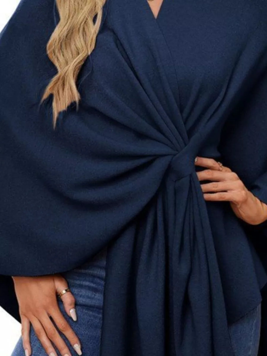 Navy knit cape top with tie-front detail and draped elegance.