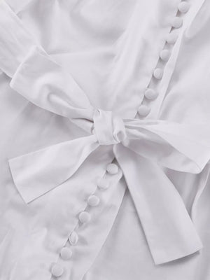 White button-up shirt with a tie waist and fabric-covered buttons
