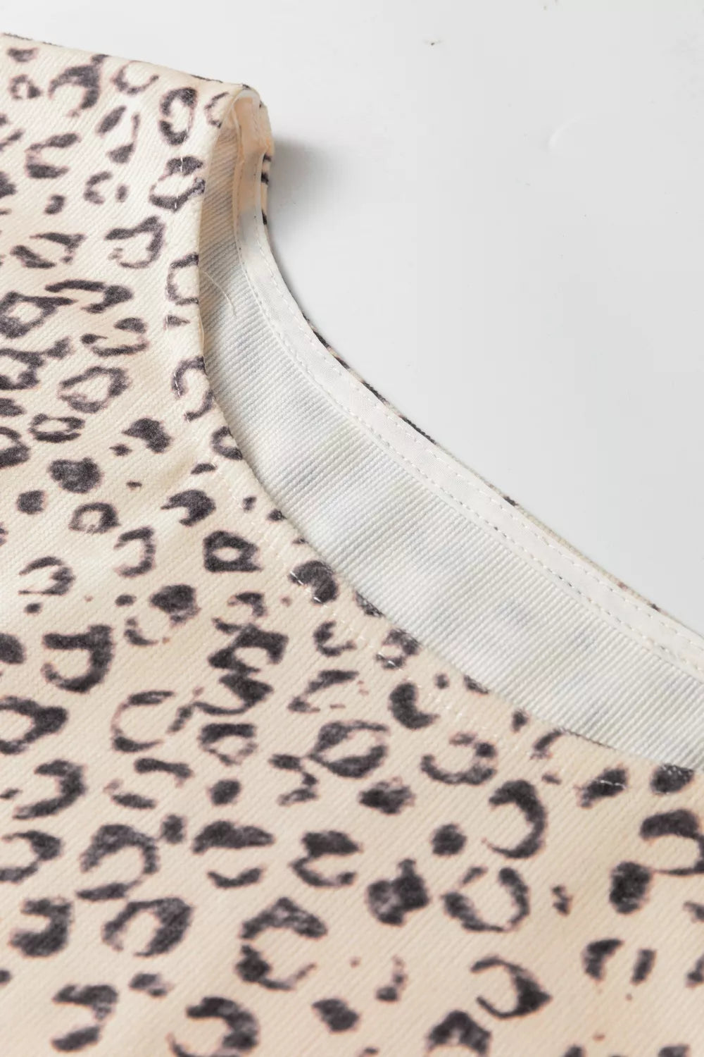 Knot detail leopard print tank top in cream and black with a ribbed neckline.