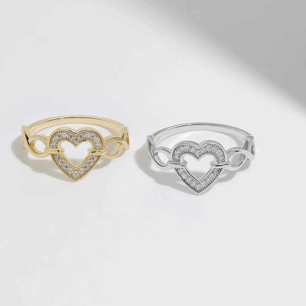 Gold and silver rings with pavé heart design and intertwined band detail.