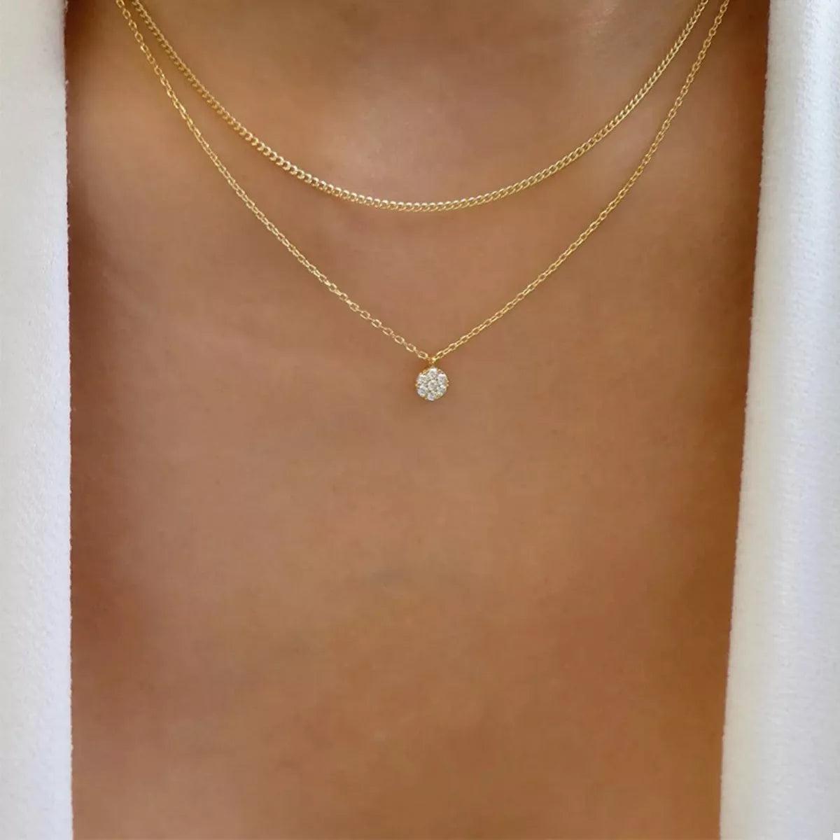Gold double layered necklace with a small sparkling pendant.