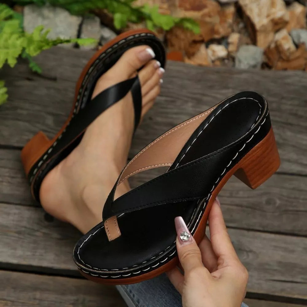 Black toe-post block heel sandals with contrast stitching and wooden heel detail.