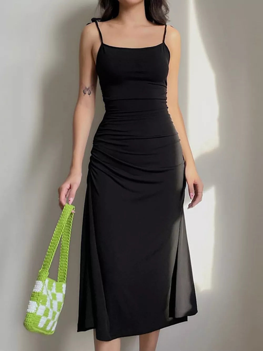 Black ruched midi dress with tie straps and a square neckline.
