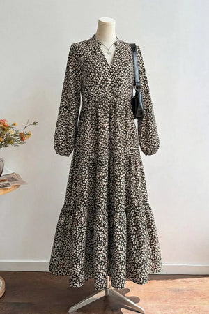 Chic black midi dress with animal print, V-neck, balloon sleeves, and tiered skirt.