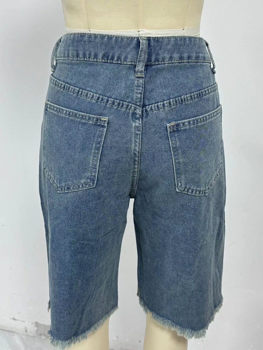 Blue denim bermuda shorts with frayed hem and relaxed fit.