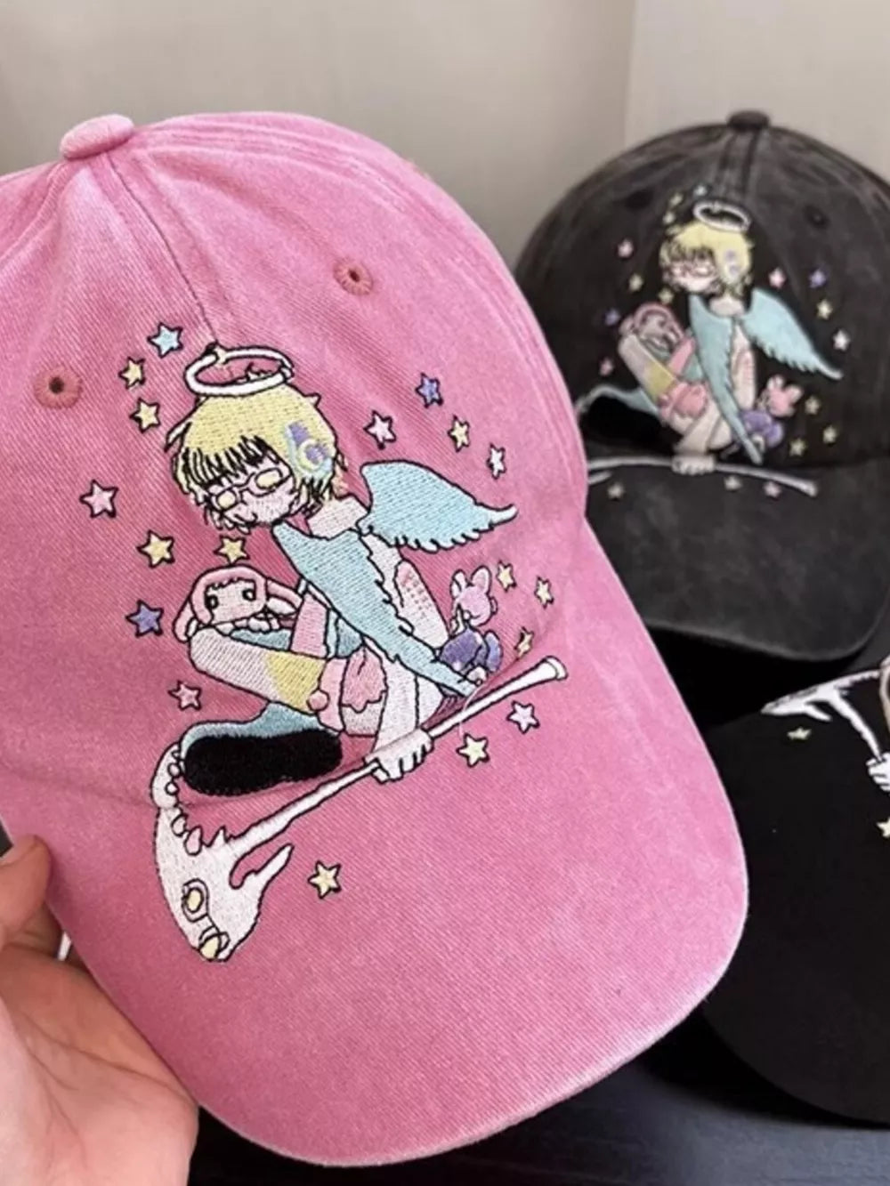 Pink cotton baseball cap with whimsical angel embroidery and stars.